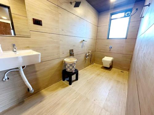 a bathroom with a sink and a toilet at VIDHI VILLA -Besides Valley View 360 with Luxurious Swimming pool & AC in Mahabaleshwar