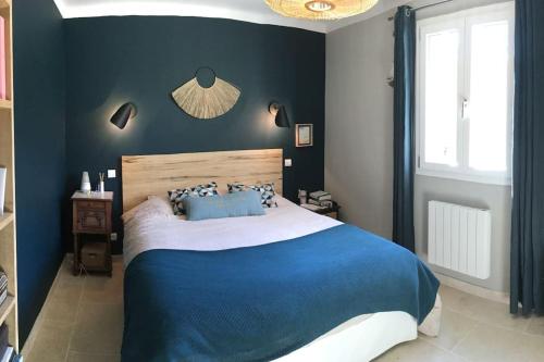 - une chambre avec un lit bleu et blanc et une fenêtre dans l'établissement Maison piscine centre St Rémy de Provence 8 pers., à Saint-Rémy-de-Provence