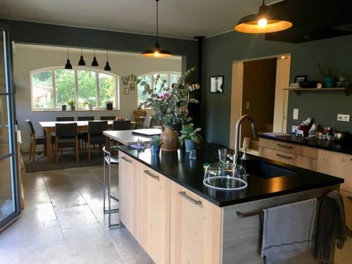 une cuisine avec un évier et une salle à manger dans l'établissement Maison piscine centre St Rémy de Provence 8 pers., à Saint-Rémy-de-Provence