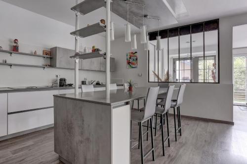 une cuisine avec une table et des chaises dans une pièce dans l'établissement L'Ulysse, à Méré