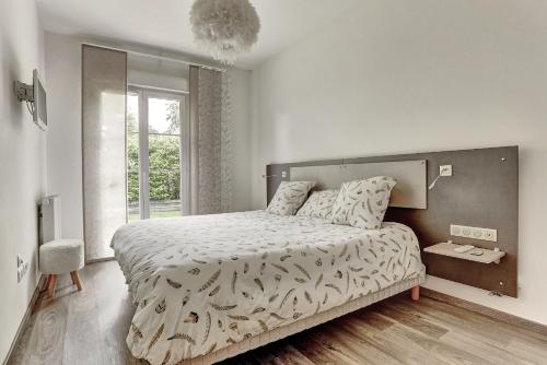Un dormitorio con una cama grande y una ventana en L'Ulysse, en Méré