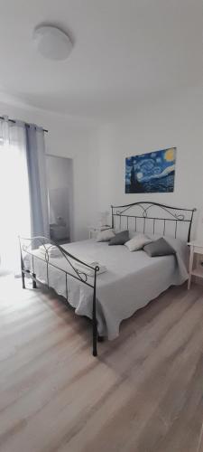 een slaapkamer met een groot bed in een witte kamer bij Margherita Guest House in Olbia