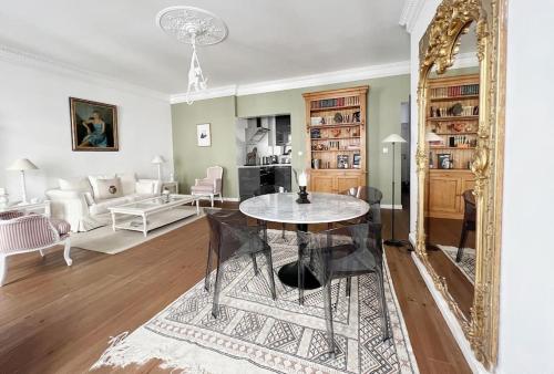 ein Wohnzimmer mit einem Tisch und einem Spiegel in der Unterkunft Le Victoire in Nantes
