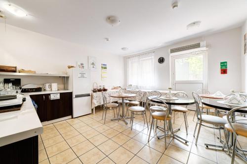 cocina y comedor con mesas y sillas en Pokoje Hotelowe Norbit, en Grodzisk Mazowiecki
