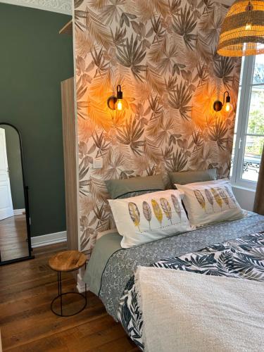 - une chambre avec un lit orné d'un mur fleuri dans l'établissement Appartement chic et cosy, à Épernay