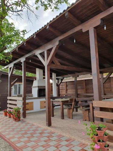 a wooden pavilion with a picnic table and benches at Pensiunea Aurelia in Şiria