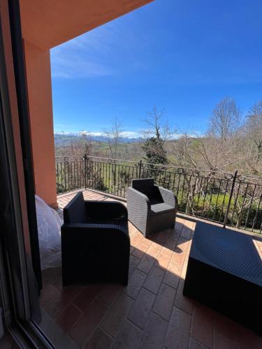 a patio with two chairs and a balcony with a view at casa mimose rosa II in SantʼAngelo in Pontano