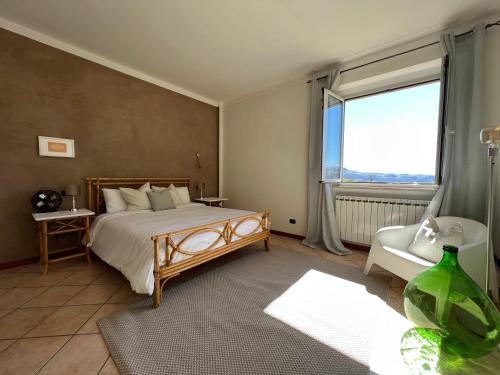 um quarto com uma cama e uma grande janela em casa mimose rosa II em SantʼAngelo in Pontano