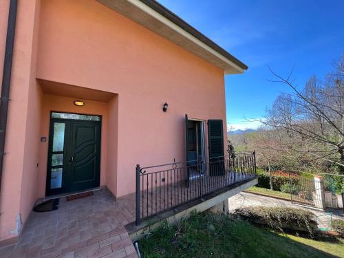 a pink house with a green door and a balcony at casa mimose rosa II in SantʼAngelo in Pontano