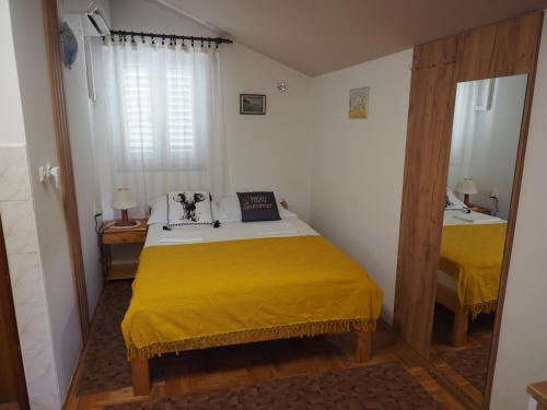 a bedroom with two beds with yellow sheets at Apartments Miro Kornić in Kornić