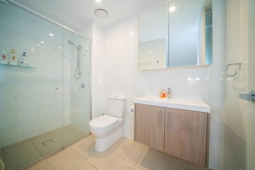 a bathroom with a toilet and a shower and a sink at Governor Place-Modern Complex in Kingston 