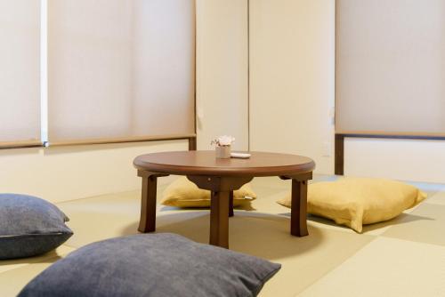 a coffee table in a room with two pillows at R-house 3rd in Takasagochō
