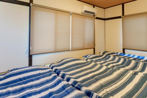 a bed sitting in a room with a window at R-house 3rd in Takasagochō
