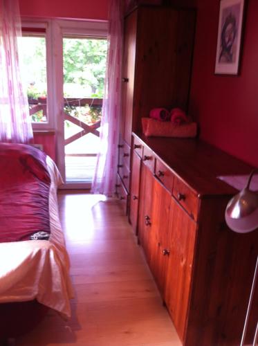 a bedroom with a bed and a dresser and a window at Brīvdienu māja"Jauneglites" in Skulte