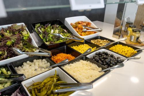 a buffet with many trays of different types of food at Dos Playas - 30º hotels in Puerto de Mazarrón