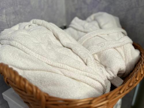 a basket filled with white towels on a table at Villa Romasi in Leuca