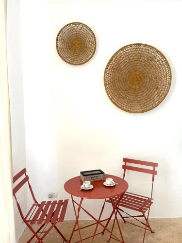 a table with two chairs and a table with a laptop at Villa Romasi in Leuca