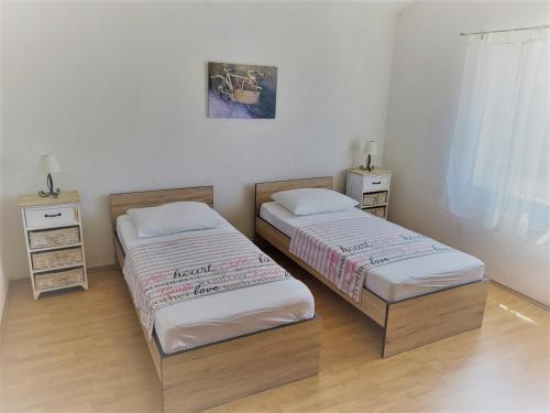 2 camas en una habitación con 2 mesitas de noche en Primošten Apartman Dino en Primošten