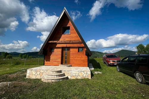 uma pequena cabana com um carro estacionado num campo em Planinska iskra em Žabljak