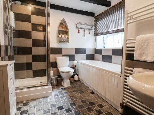 a bathroom with a tub and a toilet and a sink at Midships Cottage in Whitby