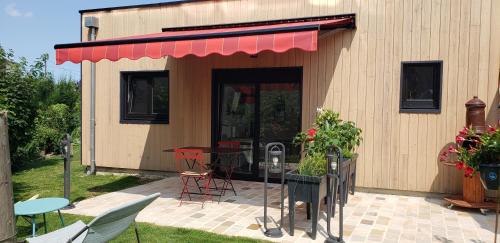 a building with a table and chairs and a patio at Dives Le petit Gîte in Dives-sur-Mer