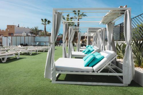 a group of white chairs sitting on a lawn at Dos Playas - 30º hotels in Puerto de Mazarrón