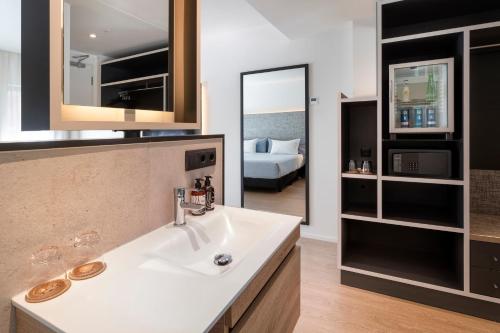 a bathroom with a sink and a bed in a room at INNSiDE by Meliá Zaragoza in Zaragoza