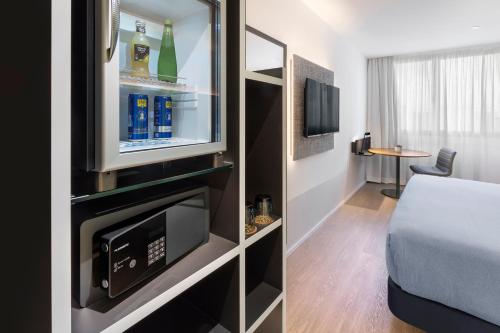 a small room with a bed and a tv at INNSiDE by Meliá Zaragoza in Zaragoza
