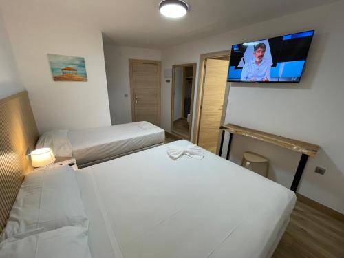 a hotel room with two beds and a flat screen tv at Pinet Playa in Alicante