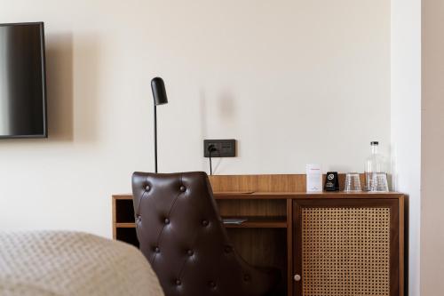 a bedroom with a bed and a desk with a chair at Fritiden Hotell & Kongress in Ystad