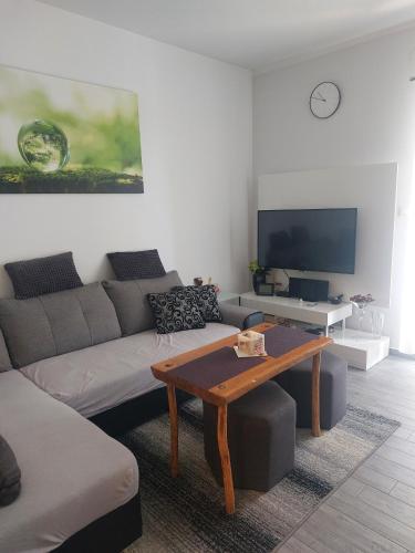 ein Wohnzimmer mit einem Sofa und einem Couchtisch in der Unterkunft Vesna Meterize A2+1 in Šibenik