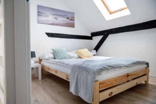 1 dormitorio con 1 cama con marco de madera en Emma Apartamenty, en Gostyń