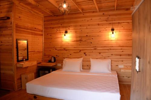 Green Pine Bungalows & Beach Luxury Concept في أولدينيس: غرفة نوم بسرير في غرفة خشبية