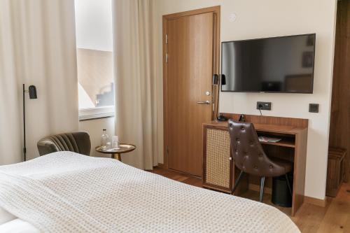 a hotel room with a bed and a television at Fritiden Hotell & Kongress in Ystad