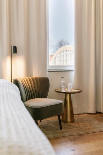 a room with a chair and a table and a window at Fritiden Hotell & Kongress in Ystad