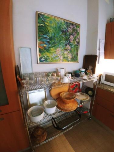 Ampi spazi, a piedi in centro. في تريفيزو: طاولة مطبخ مع صحون و لوحة على الحائط