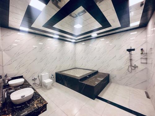 y baño con bañera y aseo. en Villa Novxani, en Baku