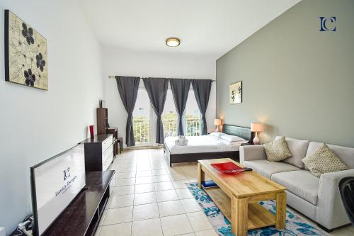 a living room with a couch and a table at Luxury Escapes - Tranquil Studio Near Furjan Metro - Relaxing Holiday Retreat in Dubai