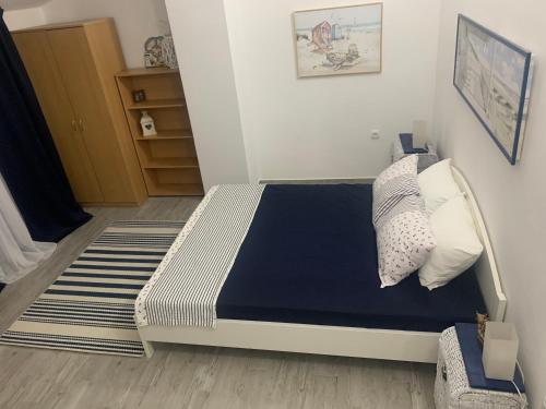 a bedroom with a bed with a blue blanket and pillows at Cozy apartment in Herceg-Novi