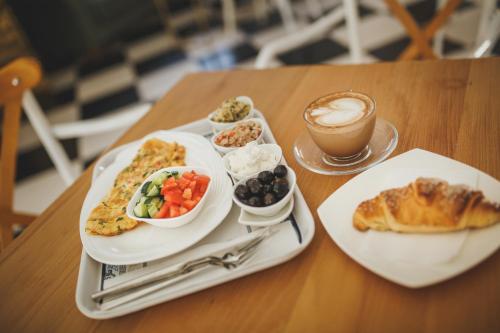 uma mesa com dois pratos de comida e uma chávena de café em Modern Apartments in Caesar Resort & SPA, Long Beach em Perivolia tou Trikomou