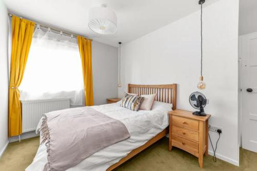 - une chambre avec un lit et un bureau avec un ventilateur dans l'établissement Serene 3BD Flat view of the Thames - Hammersmith, à Londres
