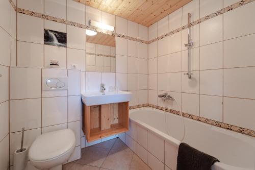 łazienka z toaletą, umywalką i wanną w obiekcie Bio Bauernhof Eggerhof w mieście Strobl
