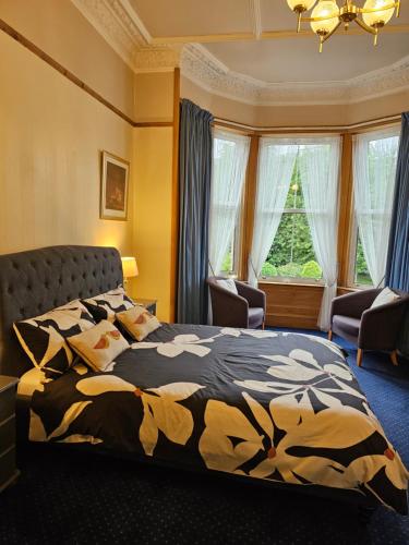 sypialnia z łóżkiem i dużym oknem w obiekcie Smiths Guest House w Edynburgu