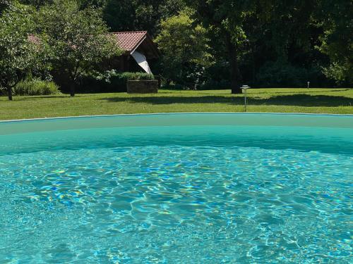 una gran piscina de agua azul en un patio en Romantisches Blockhaus an der Märchenstraße!, en Reinhardshagen