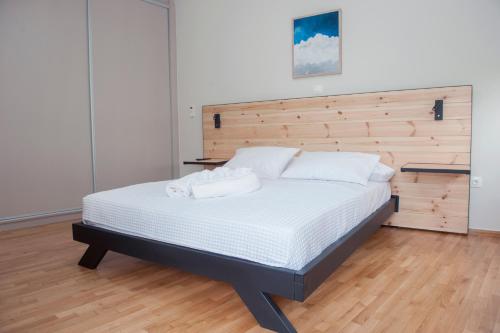 a bedroom with a large bed with a wooden headboard at Olympia luxury apartment in Marousi in Athens