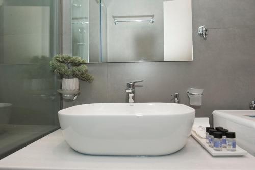 La salle de bains est pourvue d'un lavabo blanc et d'un miroir. dans l'établissement Olympia luxury apartment in Marousi, à Athènes