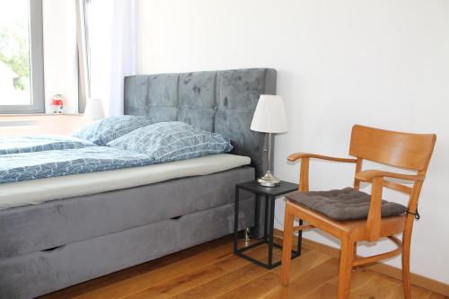 a bedroom with a bed and a chair and a lamp at Ferienwohnung Haus Knäppen Size M in Oelde