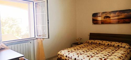 a bedroom with a bed next to a window at Casa Fiore Olbia in Olbia