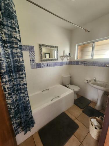 La salle de bains est pourvue d'une baignoire, de toilettes et d'un lavabo. dans l'établissement 6 Bayview, à East London