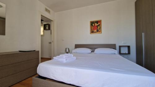 a bedroom with a white bed with towels on it at "ELLE home" ATTICO panoramico in Lecce